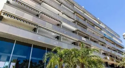 a large building with palm trees in front of it at Royal Promenade in Nice
