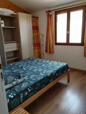 a bedroom with a bed and a window at entre terre et mer 3 pièces in Gattières
