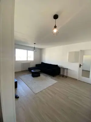 a living room with a black couch and a table at Proche promenade des anglais in Nice