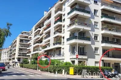 a large white apartment building with a red circle on it at Luxueux appartement, Carré d'Or, Square Mozart in Nice