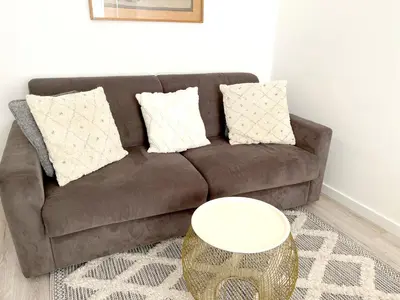 a brown couch with pillows and a table in a living room at Shared Duplex Apartment Nice-Port in Nice
