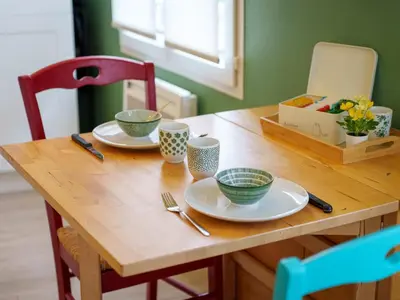 a wooden table with plates and bowls on it at Pause et Sérénité Studio de 28m2 in Cagnes-sur-Mer