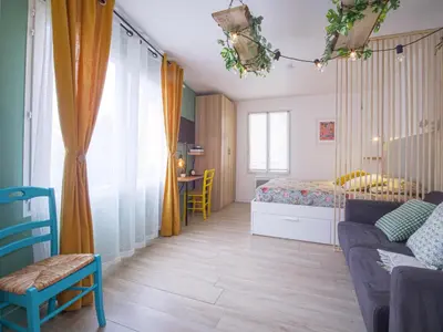 a bedroom with a bed and a couch and a table at Pause et Sérénité Studio de 28m2 in Cagnes-sur-Mer
