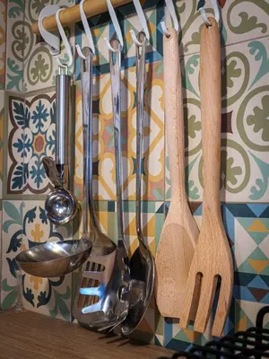 a group of kitchen utensils hanging on a wall at Pause et Sérénité Studio de 28m2 in Cagnes-sur-Mer