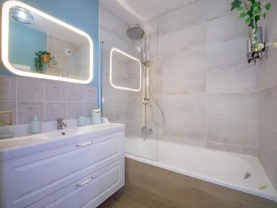 a bathroom with a sink and a tub and a mirror at Pause et Sérénité Studio de 28m2 in Cagnes-sur-Mer