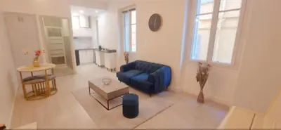 a living room with a blue couch and a table at Appartement cosy moderne calme hyper centre gare sncf in Nice
