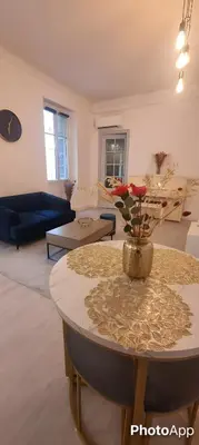 a living room with a table with a vase of flowers on it at Appartement cosy moderne calme hyper centre gare sncf in Nice