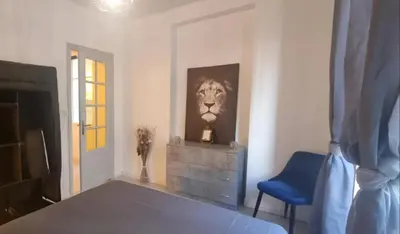 a bedroom with a lion picture and a blue chair at Appartement cosy moderne calme hyper centre gare sncf in Nice