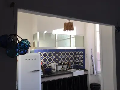 a kitchen with a white refrigerator and a sink at Appartement le Fighiéra in Nice