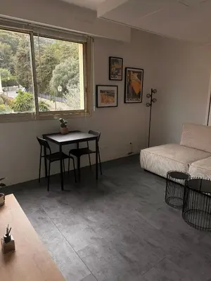 a room with a table and a bed and a window at Beau studio au cœur de Beaulieu-sur-mer in Beaulieu-sur-Mer