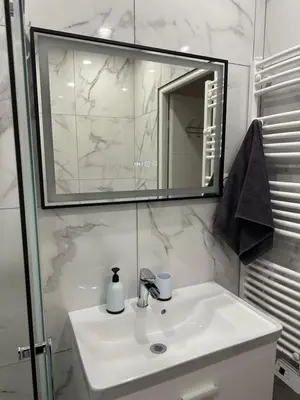 a white bathroom with a sink and a mirror at Appartement 3 pieces proche du Negresco in Nice
