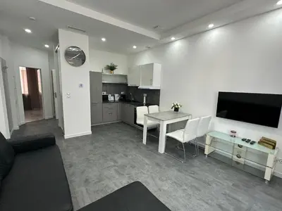 a living room with a table and a kitchen at Appartement 3 pieces proche du Negresco in Nice