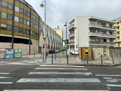 an empty city street with a building and a crosswalk at Appartement 3 pieces proche du Negresco in Nice