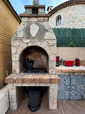 an outdoor brick oven with a grill on a patio at Glamping Dôme in Cagnes-sur-Mer