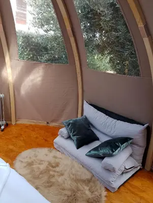 a tent in a yard next to a tree at Glamping Dôme in Cagnes-sur-Mer