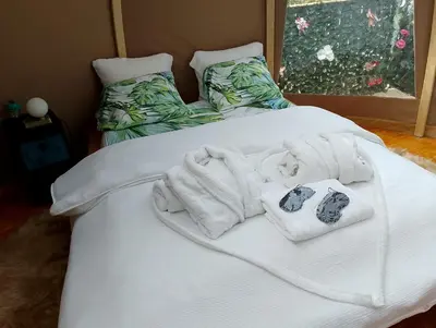 two towels and two bags on a bed at Glamping Dôme in Cagnes-sur-Mer