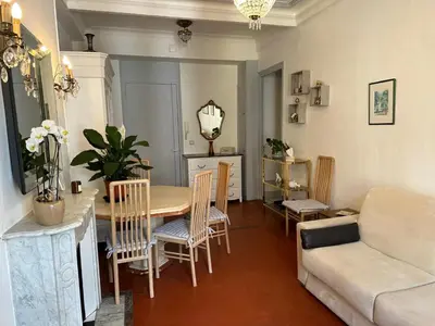 a living room with a table and chairs and a couch at Beau T2 proche Negresco in Nice