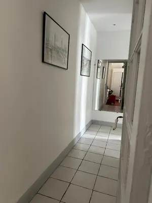 a hallway with white walls and a tile floor at Beau T2 proche Negresco in Nice