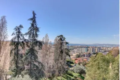 a group of trees with a city in the background at Terrasses de la Corniche, 2p 65m2 spacieux, terrasses mer & montagne, piscine et parking privé in Nice