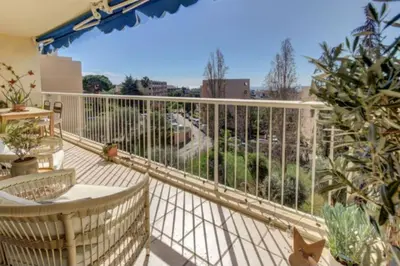 a balcony with a bird flying over a yard at Terrasses de la Corniche, 2p 65m2 spacieux, terrasses mer & montagne, piscine et parking privé in Nice