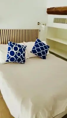 a bed with two blue and white pillows on it at Superbe Duplex avec vue ! in Villefranche-sur-Mer