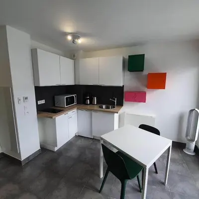 a kitchen with white cabinets and a table with chairs at Ma place au sud Nice 607 in Nice