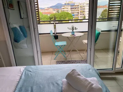 a bedroom with a bed and a balcony with a table at Ma place au sud Nice 405 in Nice
