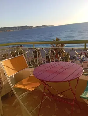 a purple table and chairs on a balcony overlooking the water at Sea Front View - FRONT DE MER ET VUE PANORAMIQUE in Nice