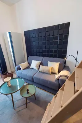 a living room with a blue couch and two tables at Charmant appartement rénové au cœur de Nice in Nice