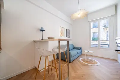 a living room with a table and a blue couch at Studio hypercentre de Nice climatisé in Nice