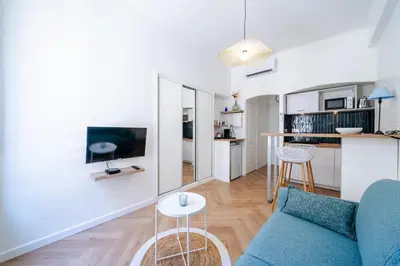a living room with a blue couch and a table at Studio hypercentre de Nice climatisé in Nice
