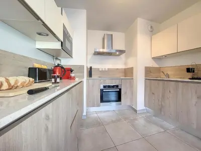 a large kitchen with wooden cabinets and appliances at Nestor&Jeeves - FRESCO - Central - Very close sea - Balcony in Nice