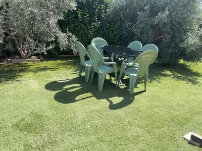 a table and chairs sitting on the grass at Maison Clémentine in Cros-de-Cagnes