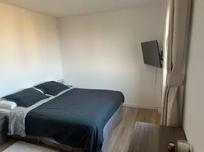 a bedroom with a bed and a television and a window at Maison Clémentine in Cros-de-Cagnes