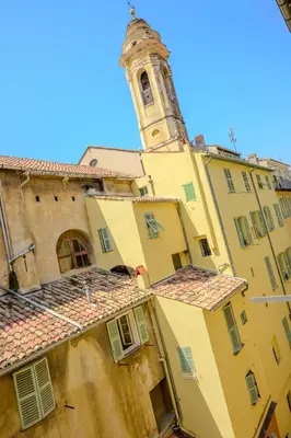 a building with a clock tower in the background at Studio au coeur du Vieux Nice - Vue mer et clocher in Nice