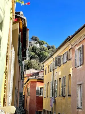 a city street with buildings and a hill in the background at Studio au coeur du Vieux Nice - Vue mer et clocher in Nice