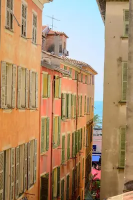 an orange building with green shutters on it at Studio au coeur du Vieux Nice - Vue mer et clocher in Nice