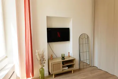 a living room with a tv on a wall at Studio au coeur du Vieux Nice - Vue mer et clocher in Nice