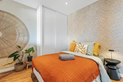a bedroom with a bed with an orange blanket at Nice Renting - ABBAYE - Luxury Penthouse Sea View Pool Tennis Parking in Nice