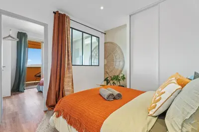 a bedroom with a large bed with an orange blanket at Nice Renting - ABBAYE - Luxury Penthouse Sea View Pool Tennis Parking in Nice