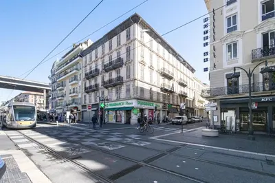 a building on a city street with a tram at Shopping et Détente au Centre Ville de Nice ! in Nice