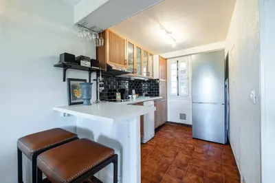 a kitchen with a white counter and a refrigerator at 2 Bdr Panoramic View on Gardens in Nice