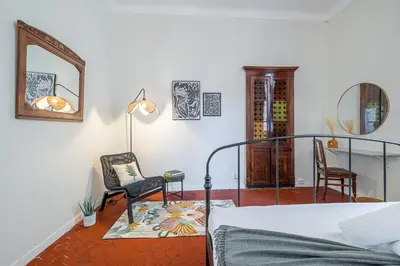 a bedroom with a bed and a chair and a mirror at 2 Bdr Panoramic View on Gardens in Nice