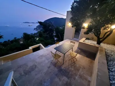 a table and chairs on a balcony with a view of the ocean at De la mer aux citronniers in Èze
