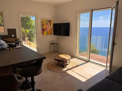 a kitchen with a table and chairs and a painting at De la mer aux citronniers in Èze