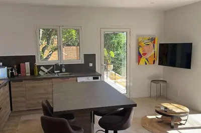 a living room with a bar with chairs and a painting at De la mer aux citronniers in Èze