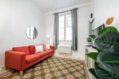 a living room with a red couch and a window at 2 Bdr with Independent Studio - Old Town in Nice