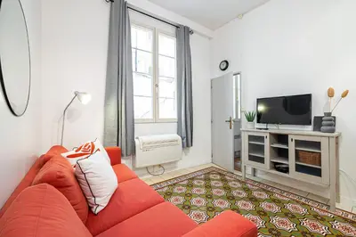 a living room with a red couch and a tv at 2 Bdr with Independent Studio - Old Town in Nice