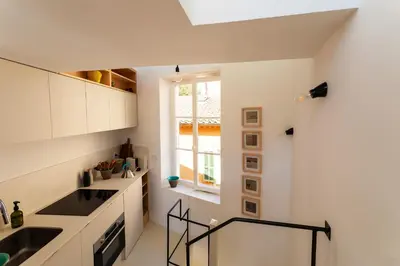 a kitchen with white cabinets and a sink and a window at LA CASETTA DI AZZURRA AP4427 By Riviera Holiday Homes in Villefranche-sur-Mer