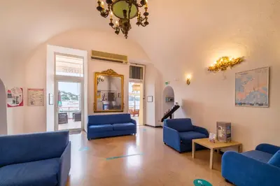 a living room with blue chairs and a chandelier at Résidence Partenaire Le Palais de la Marine in Villefranche-sur-Mer